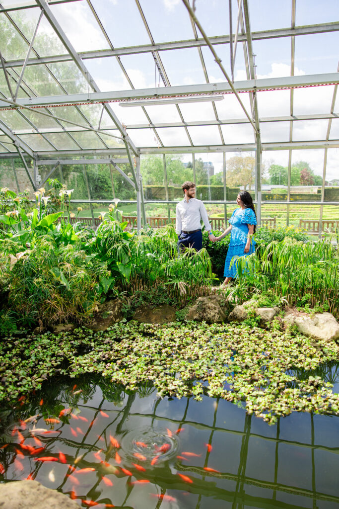 bride and groom walk through gardens 