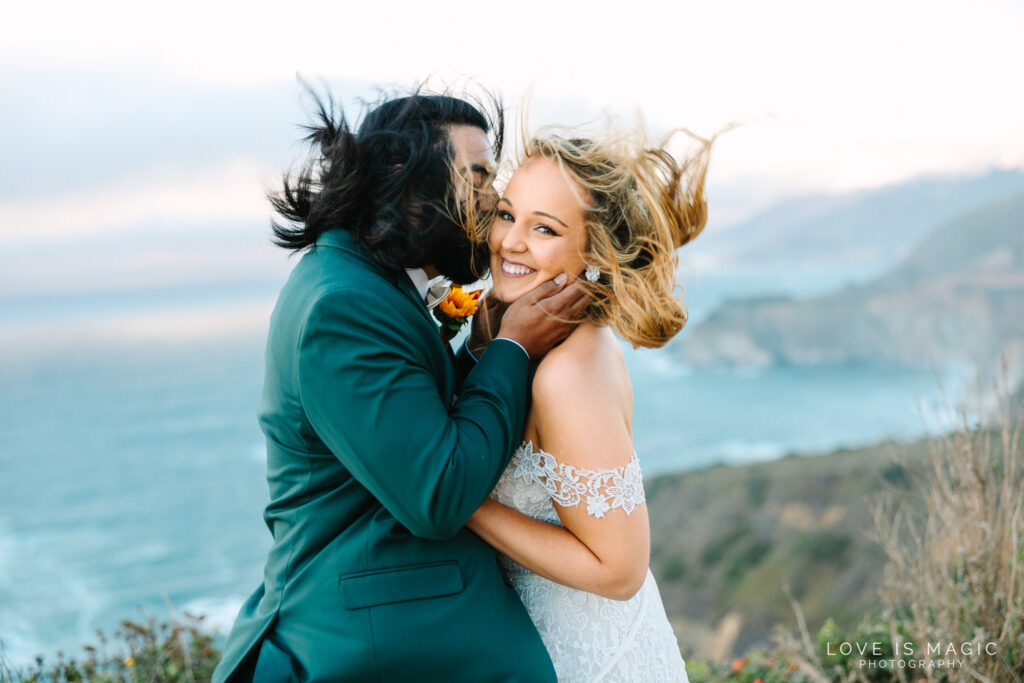 bride and groom kiss while wind blows hair