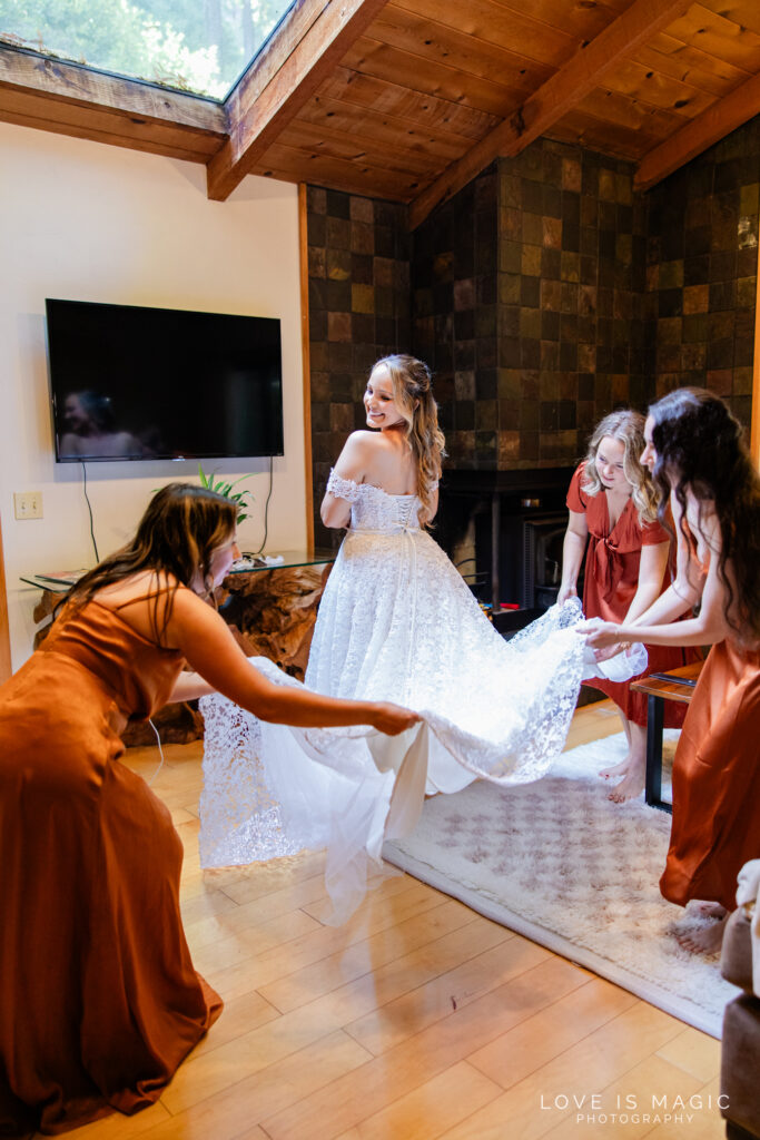bridesmaids adjusting brides dress