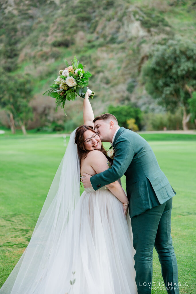 bride cheers as groom kisses her cheek, photo by Love is Magic Photography