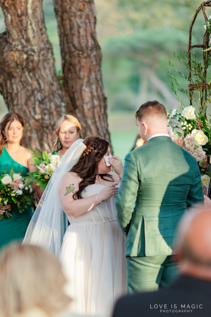 bride wipes tear from her face, photo by Love is Magic Photography