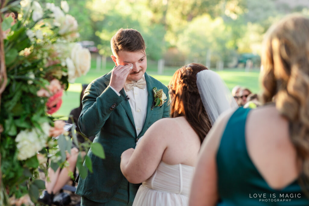 groom wipes tear from his face, photo by Love is Magic Photography