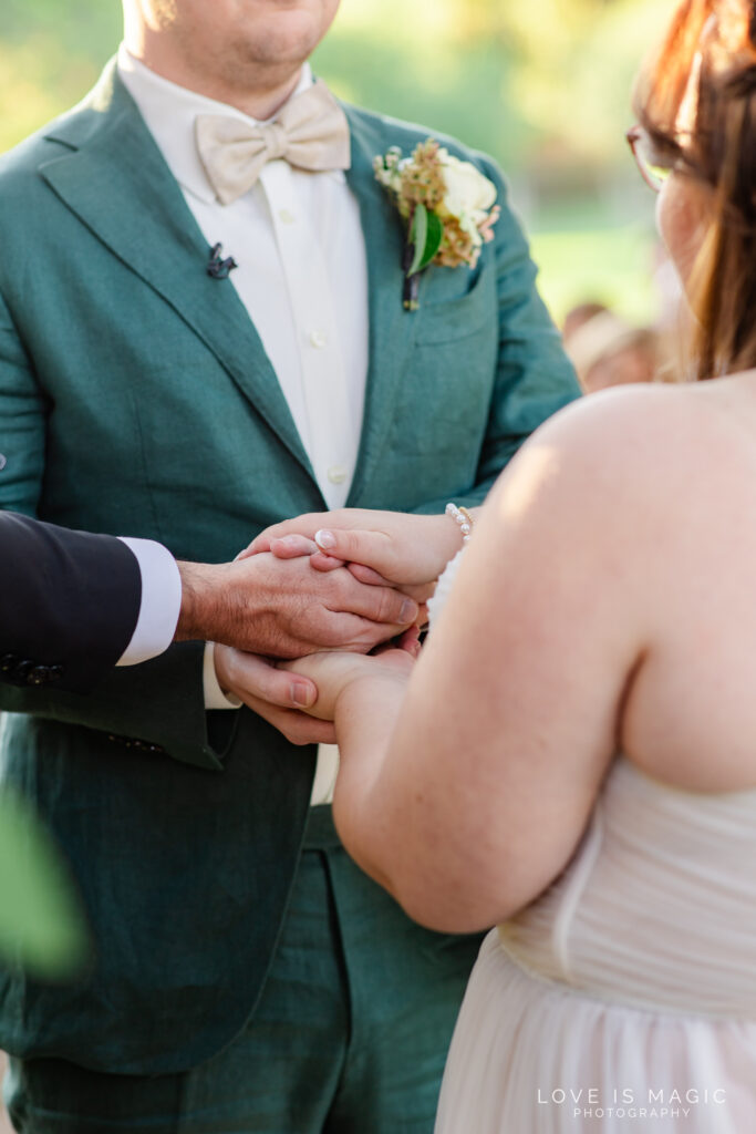 bride and groom join hands during their vows, photo by Love is Magic Photography