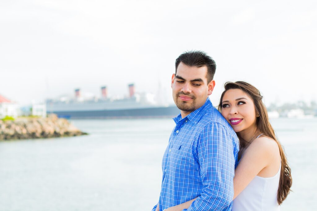 Long Beach engagement couple poses in front of Queen Mary