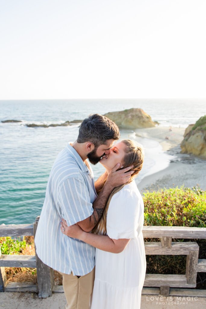 girl kisses boy at their beach engagement session, photo by Love is Magic Photography