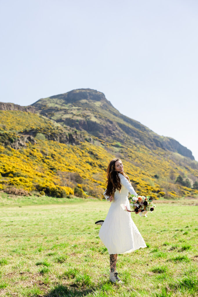 Bride spinning in field under Arthur's Seat Bride spinning in field under Arthur's Seat