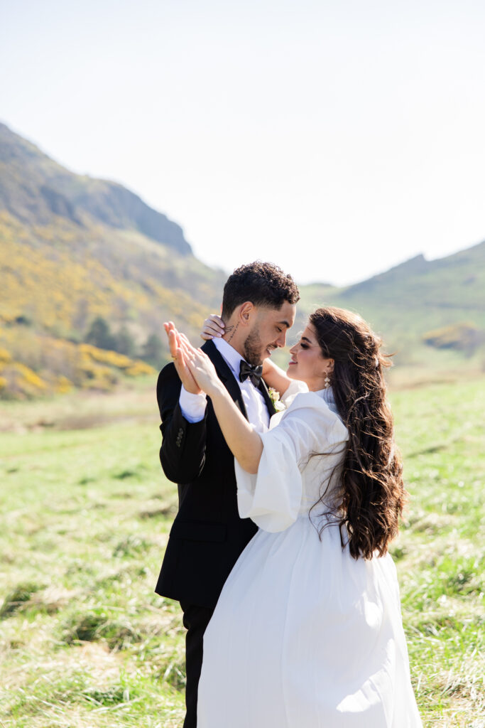 bride and groom hold hands on Arthur's Seat bride and groom hold hands on Arthur's Seat