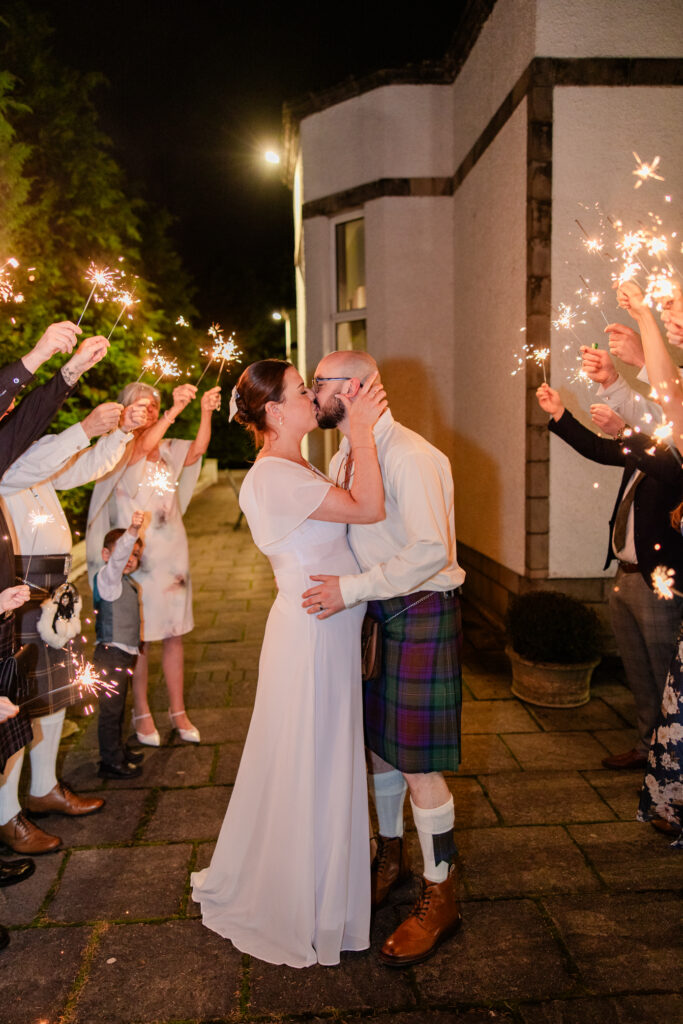 Emotional wedding photography in Falkirk capturing heartfelt moments between family holding sparklers
