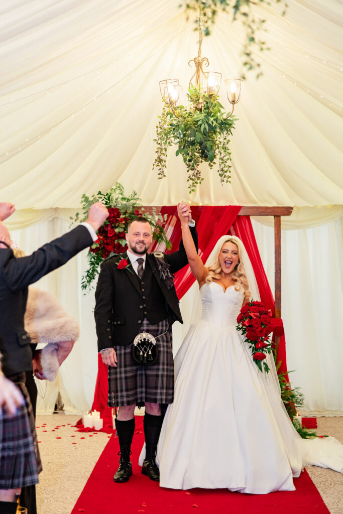 Bride and groom excited at their wedding ceremony in white marquee at Cornhill Castle