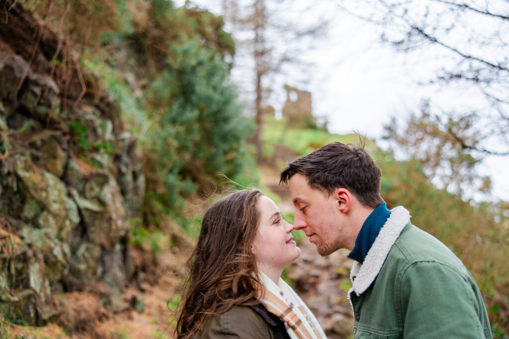 couple kissing in a forest and chaple ruins