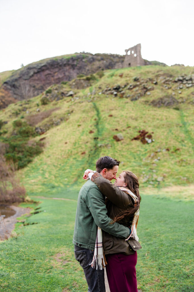 couple kissing on rolling green hills