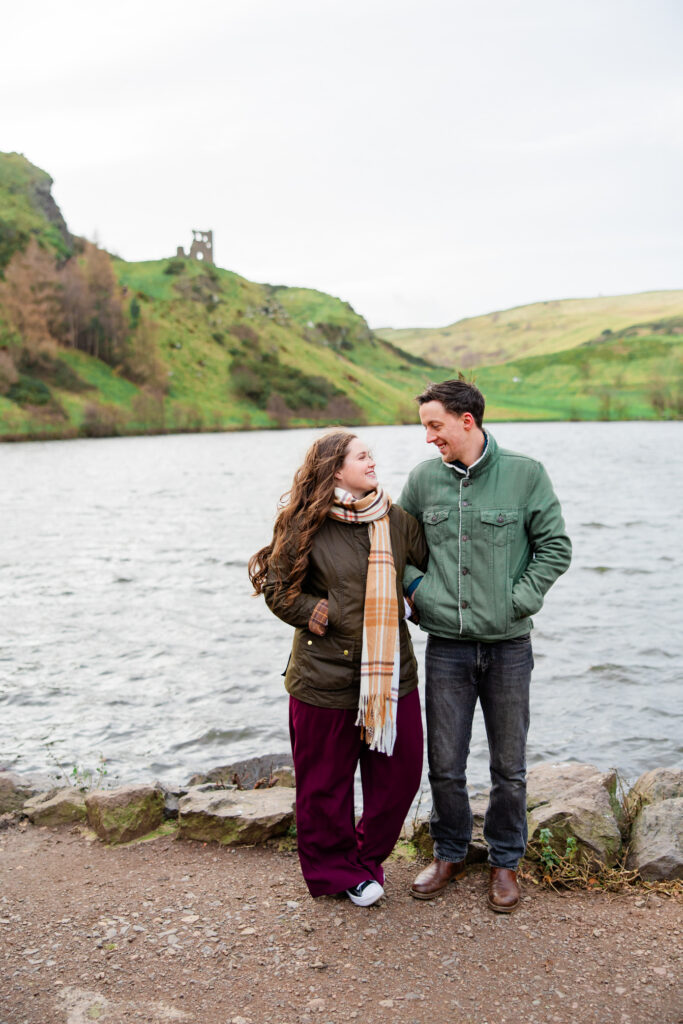 couple stands on the shores of a loch