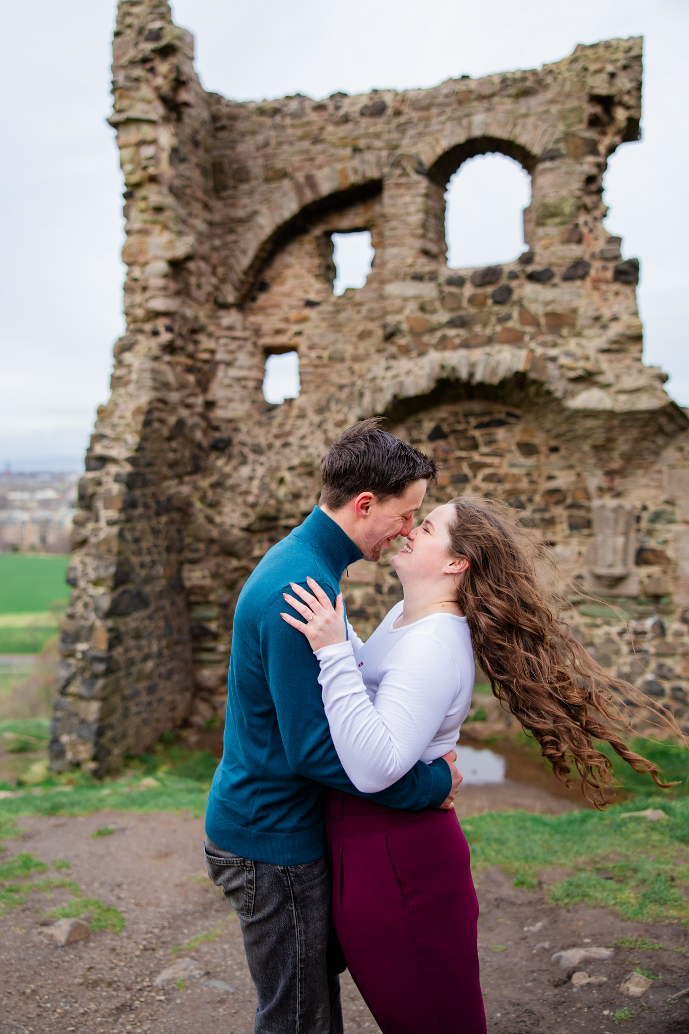 girls hair blowing in the wind as she laughs with her fiance