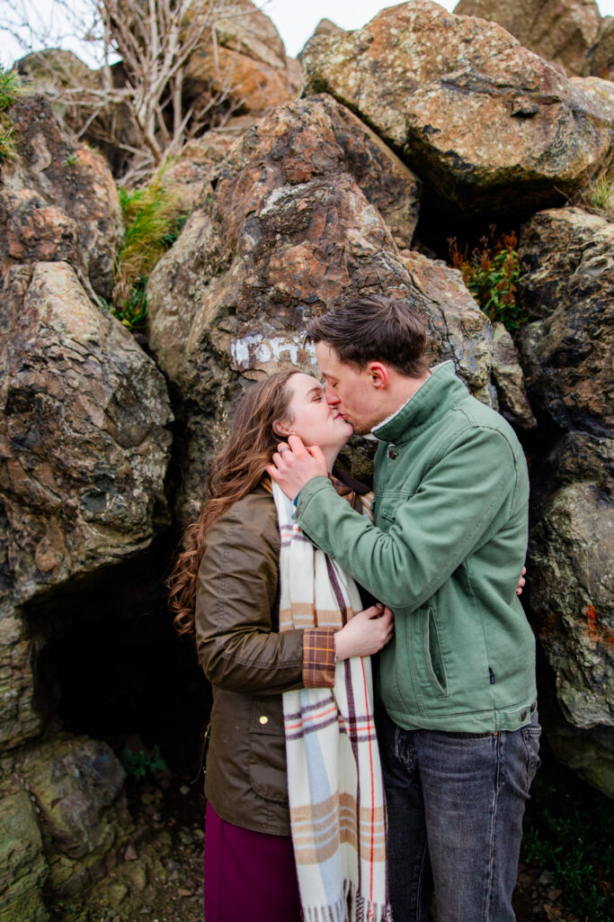kissing with large rocks on a hillside