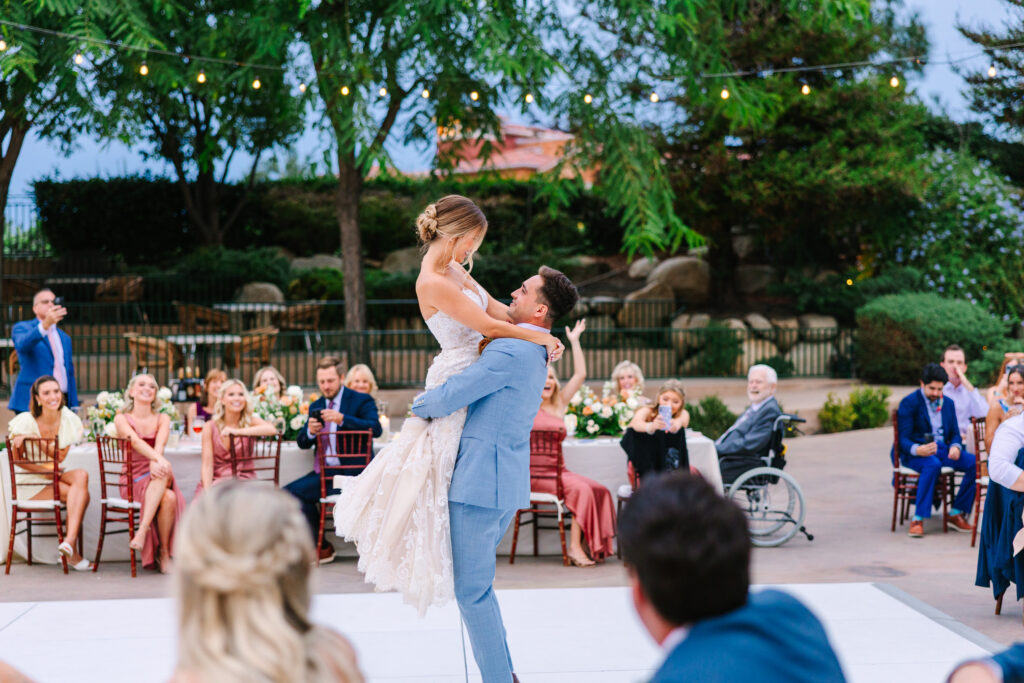 groom lifts bride at their first dance