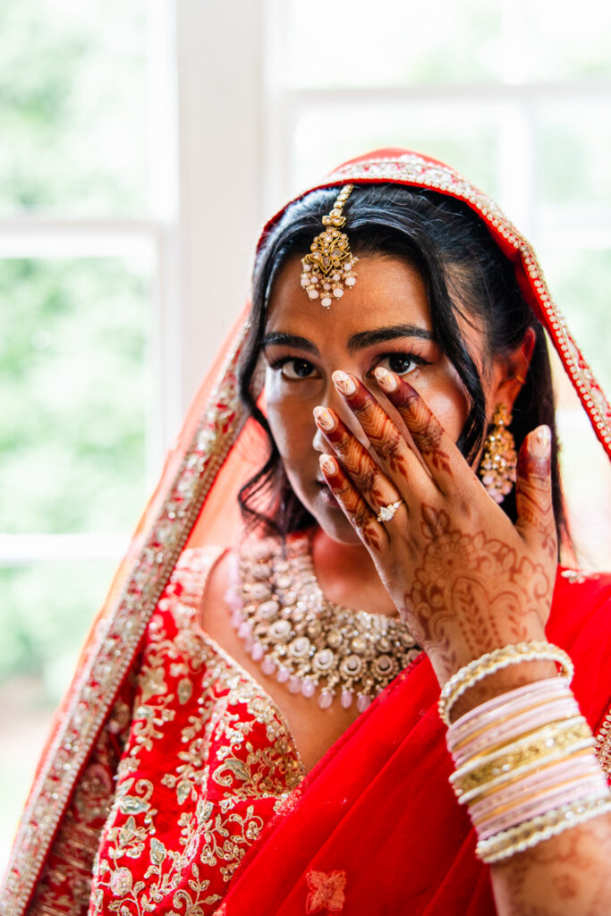 Bridal portrait showing henna, engagement ring and traditional red wedding attire