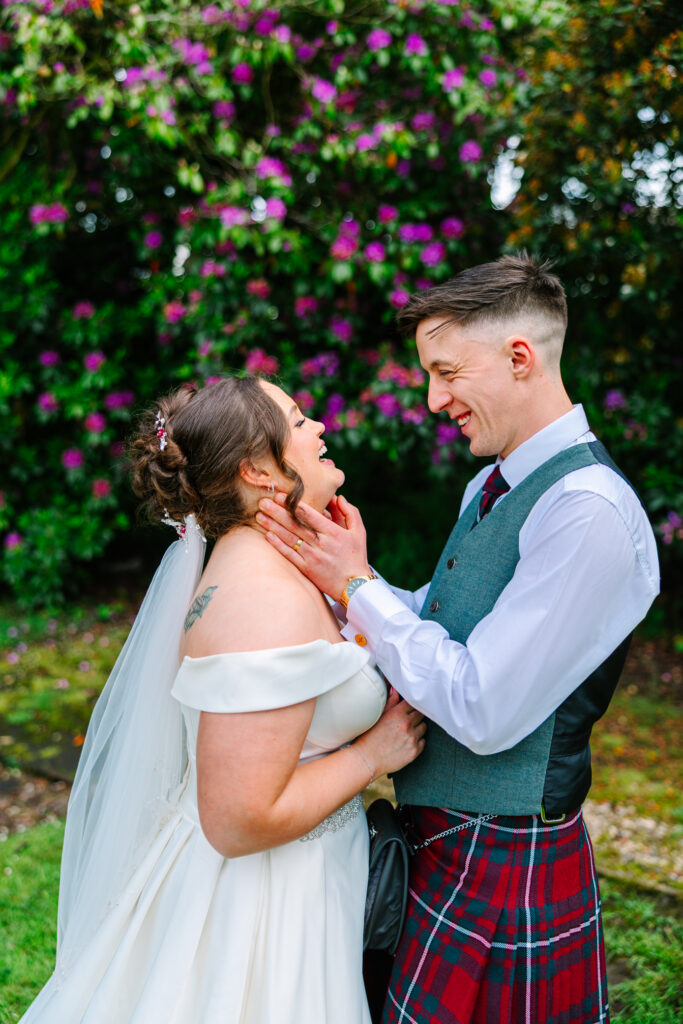Bride and groom laughing together during relaxed wedding portraits at Kilmardinny House