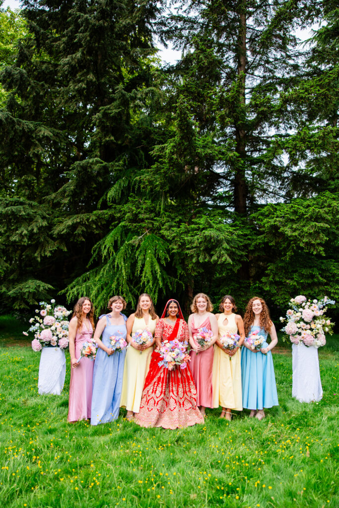 Bride with bridesmaids holding pastel bouquets in the gardens at Melville Castle wedding venue
