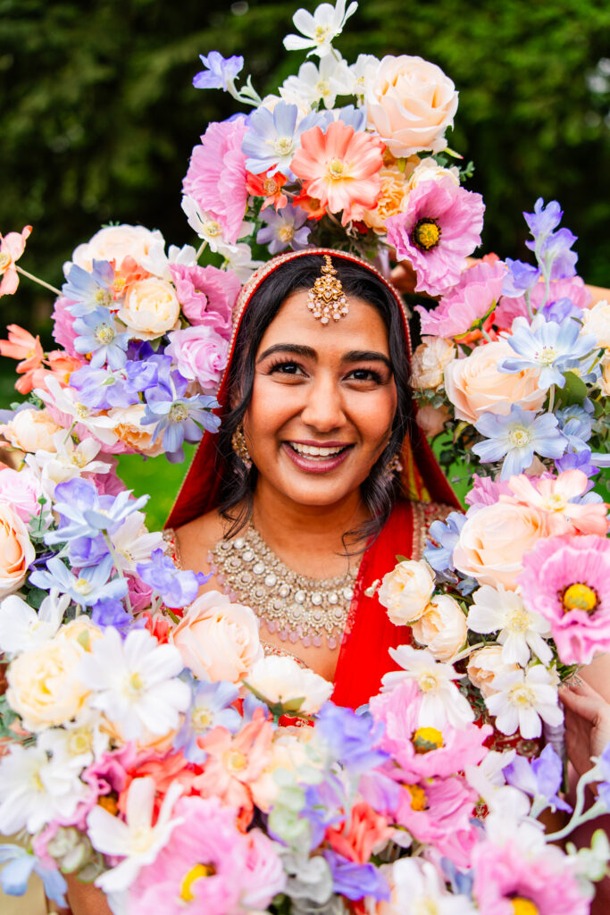 Colourful bridal portrait framed by pastel flowers during a Melville Castle wedding in Scotland