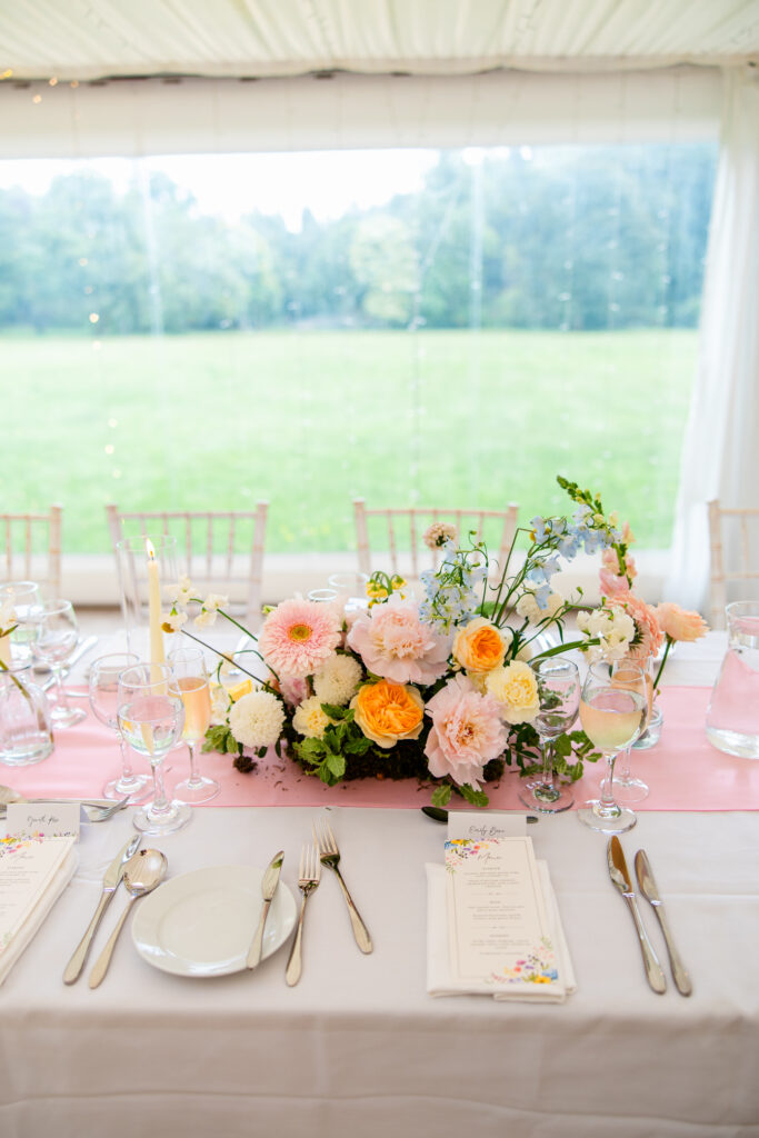 Head table decorated with pastel floral arrangements overlooking the Melville Castle grounds