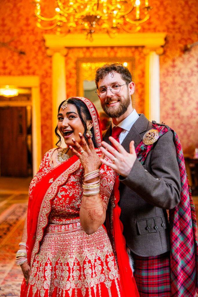 Newlyweds showing their wedding rings inside Melville Castle after their ceremony