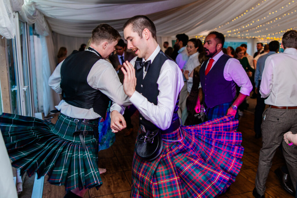 Wedding guests in Scottish kilts dancing during the evening reception at Melville Castle