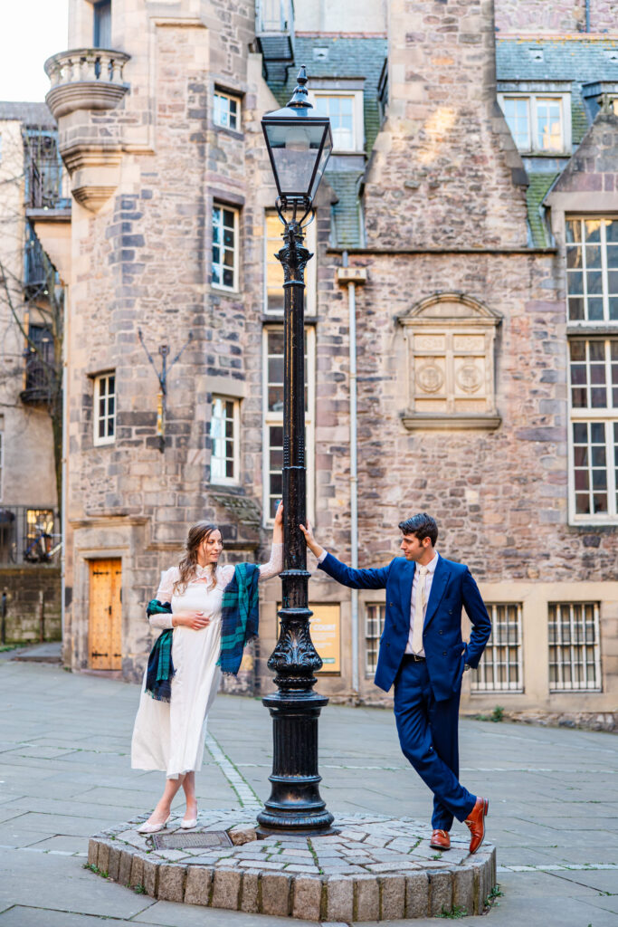 Newlywed couple walking through Edinburgh's historic Old Town streets during their wedding portraits