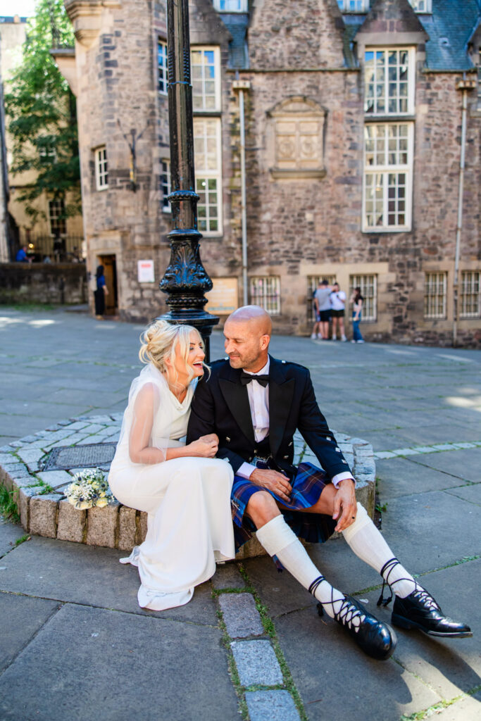 Newlyweds sitting together on the steps of Edinburgh Old Town